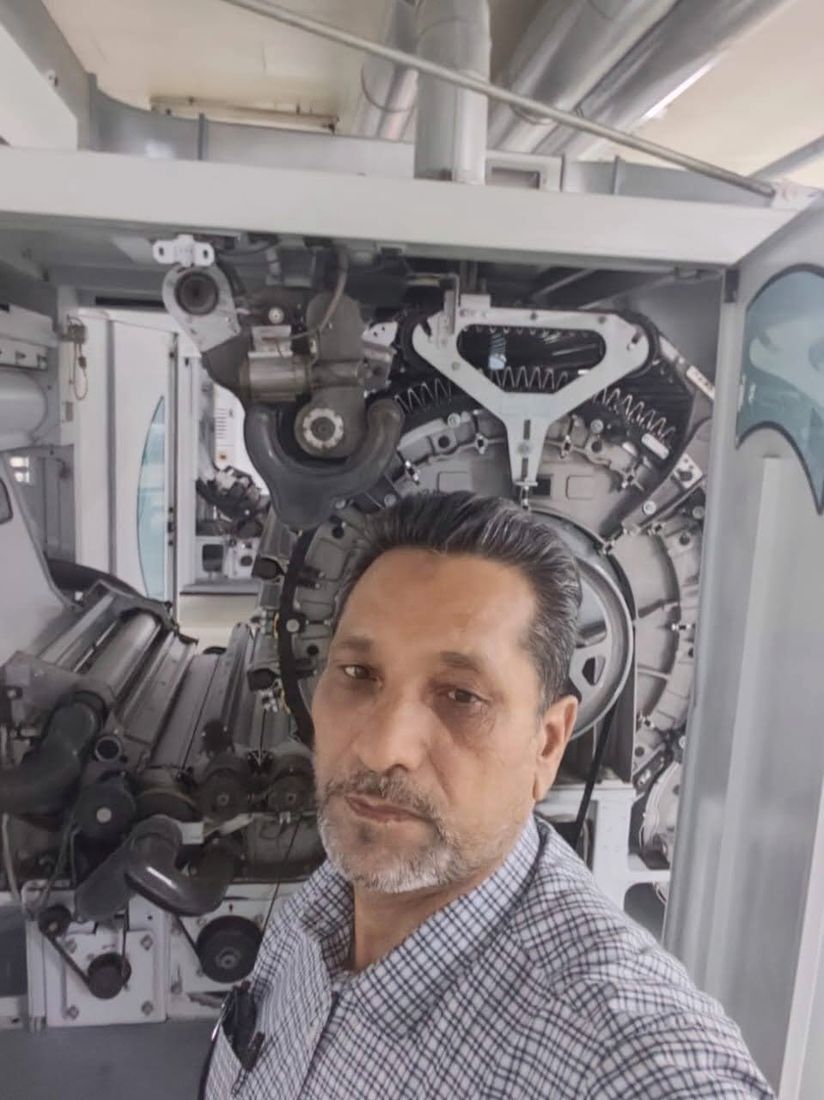 Abdul Rasheed Gill beside an opened carding machine